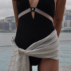 Person wearing a black and white dress with a cityscape in the background